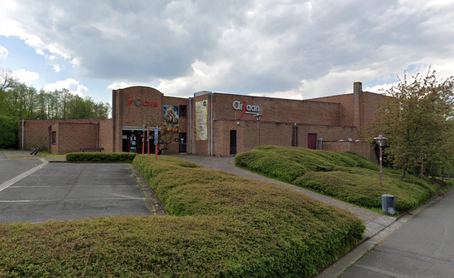 Gevel van bioscoop Focus met parking en heggen.