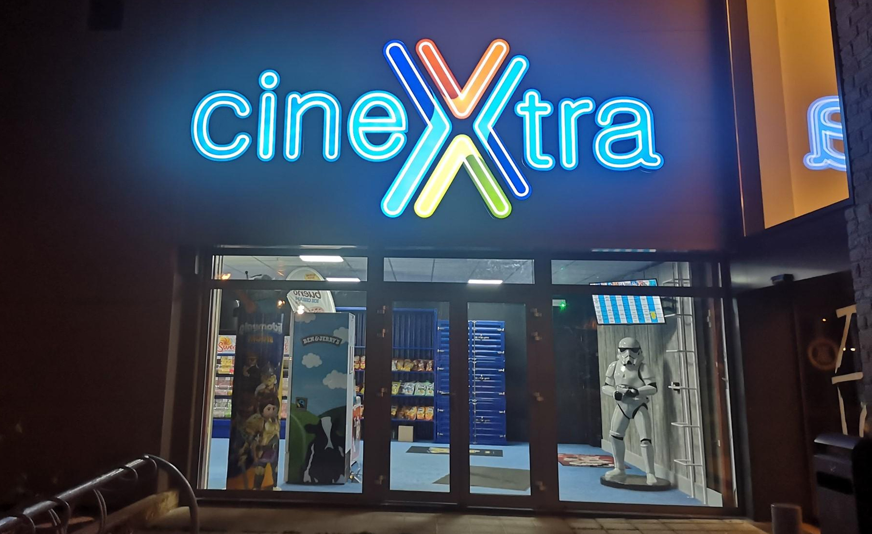 Gevel van CineXtra bioscoop Bastogne bij avond met verlichte logo
