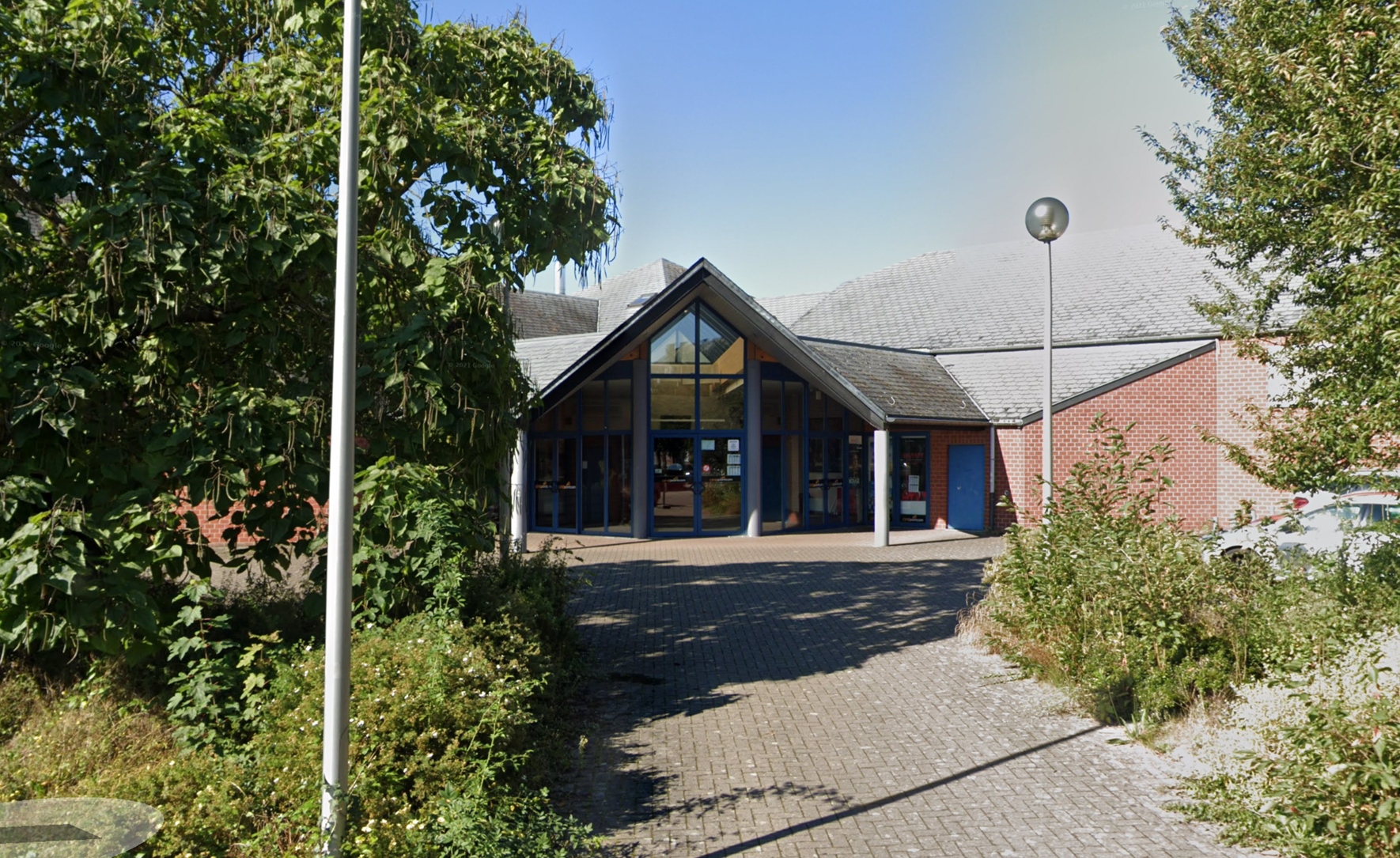 Ingang van CineXtra bioscoop Marche met glazen puntgevel en bakstenen gebouw.