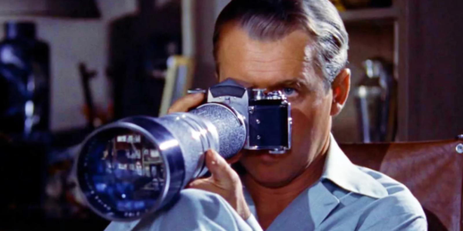 Man kijkt door een filmcamera met een lange lens.